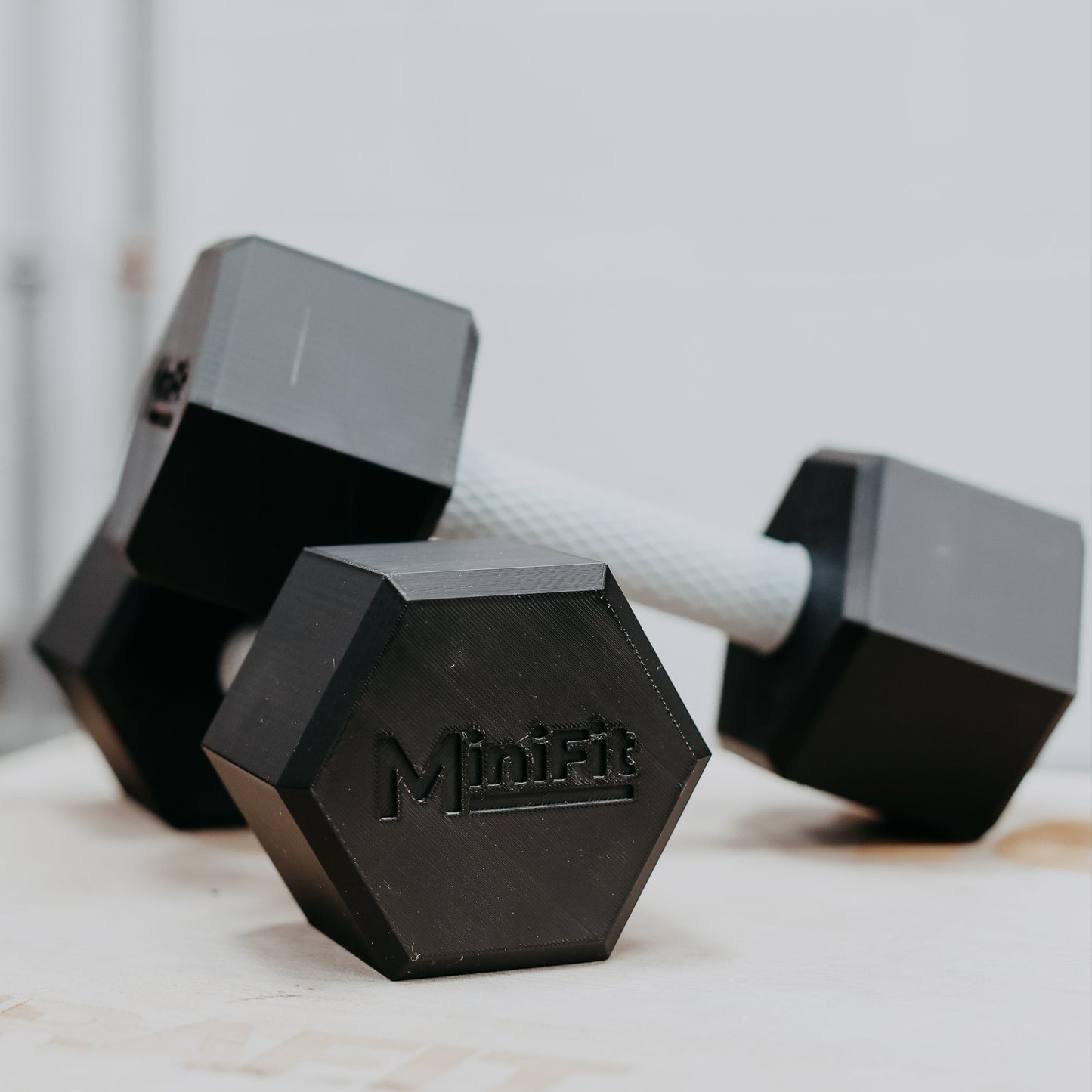 Pair of black children's dumbbells on a wooden surface