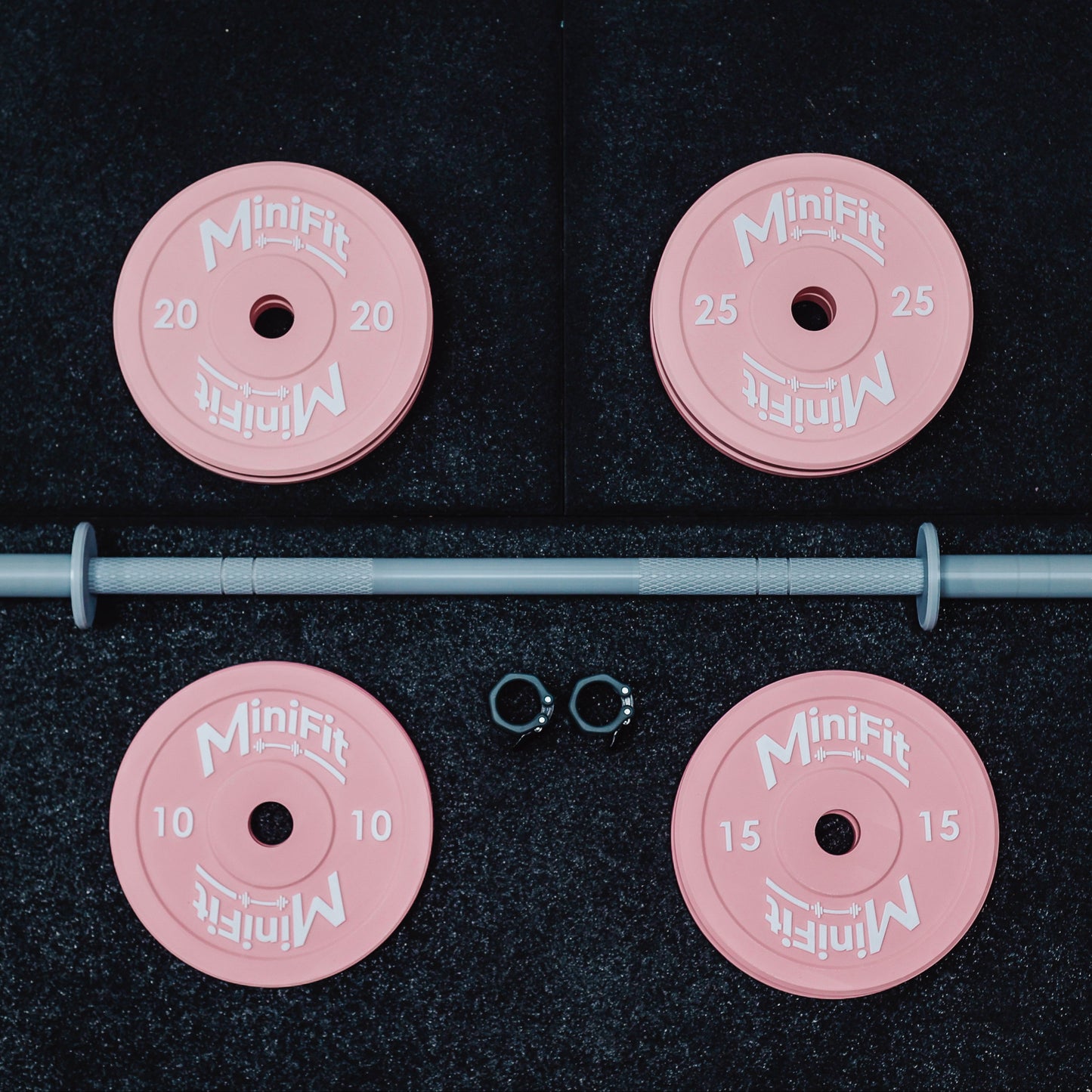 Pink weight plates with a bar on a black background