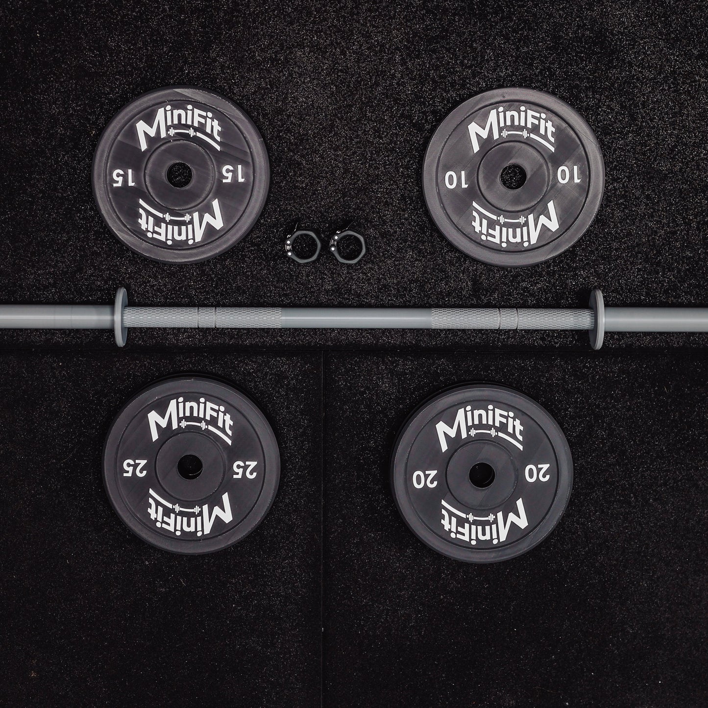 Set of child's weight plates and barbell on a black gym mats