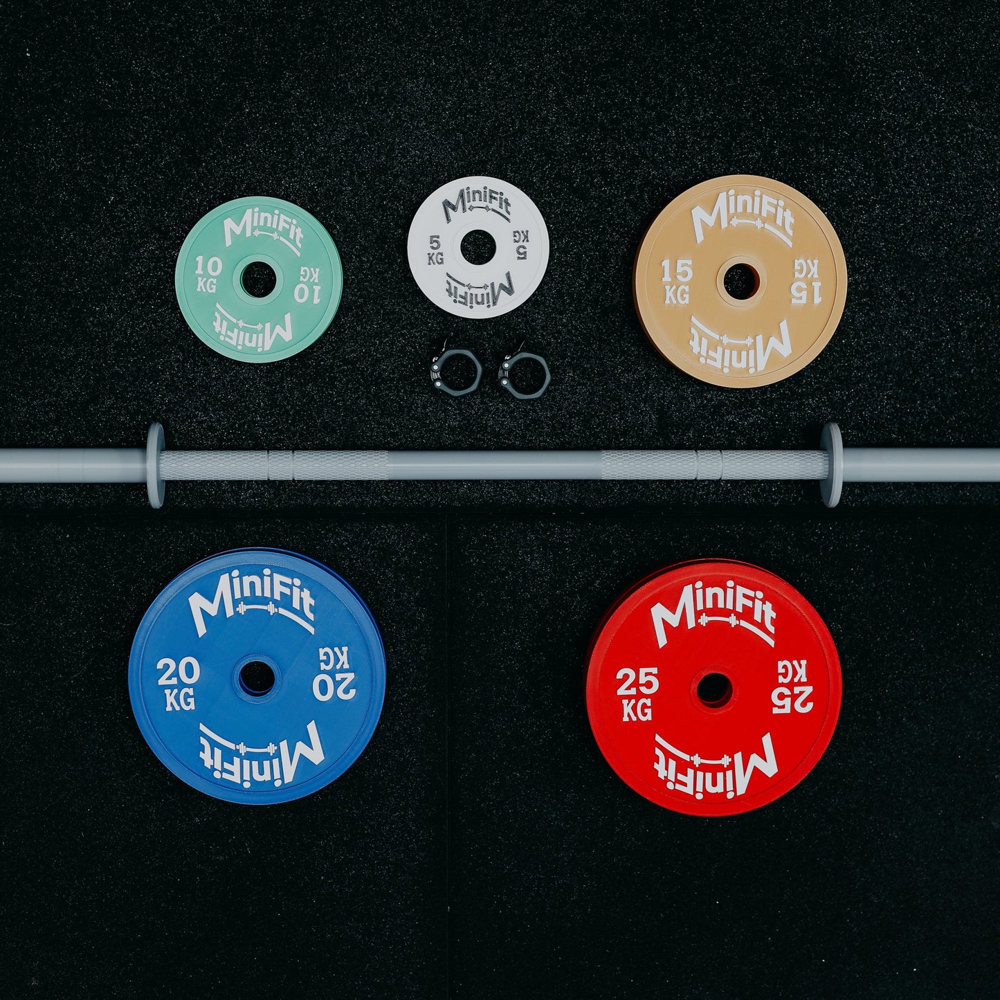 Set of children's Minifit weight plates and bar on a black gym mat