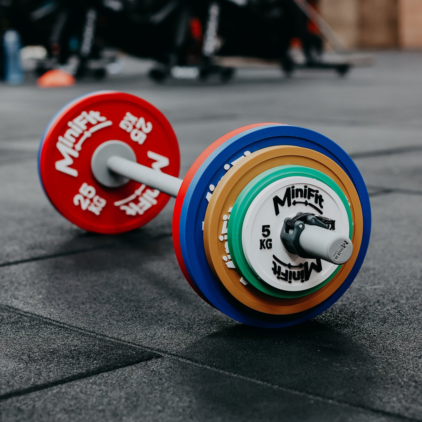 Colourful children's powerlifting barbell set on a gym floor