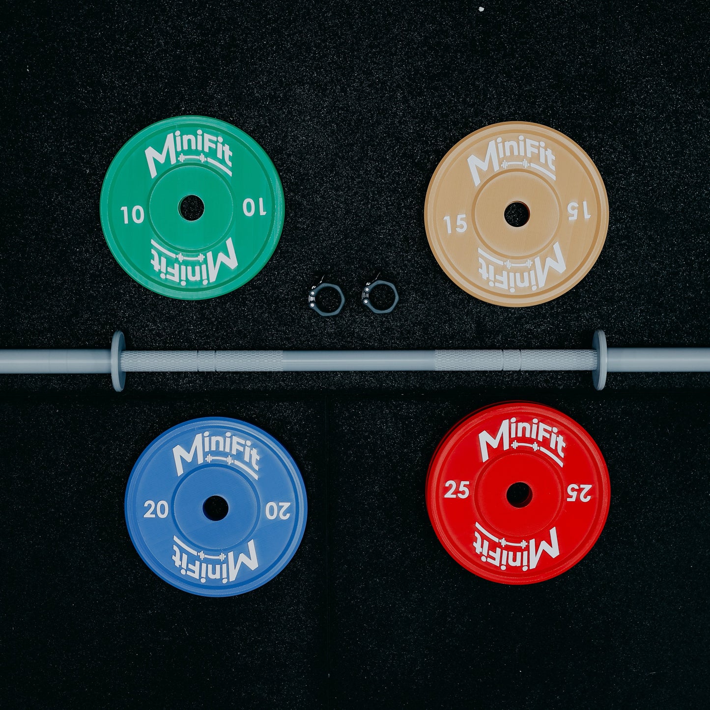 Set of Minifit kids weight plates with a bar on a black gym mat