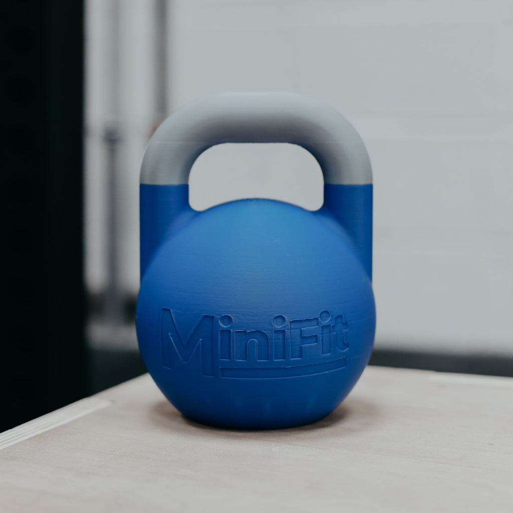 Blue mini kids fitness kettlebell weight with MiniFit branding on a wooden surface.