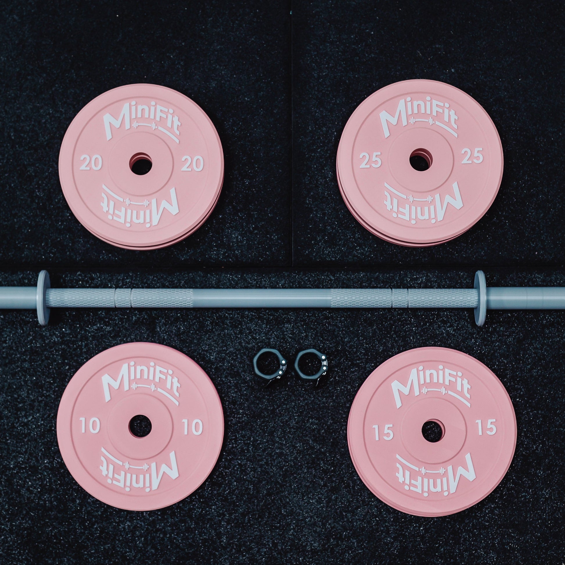 Pink weight plates with a bar on a black background