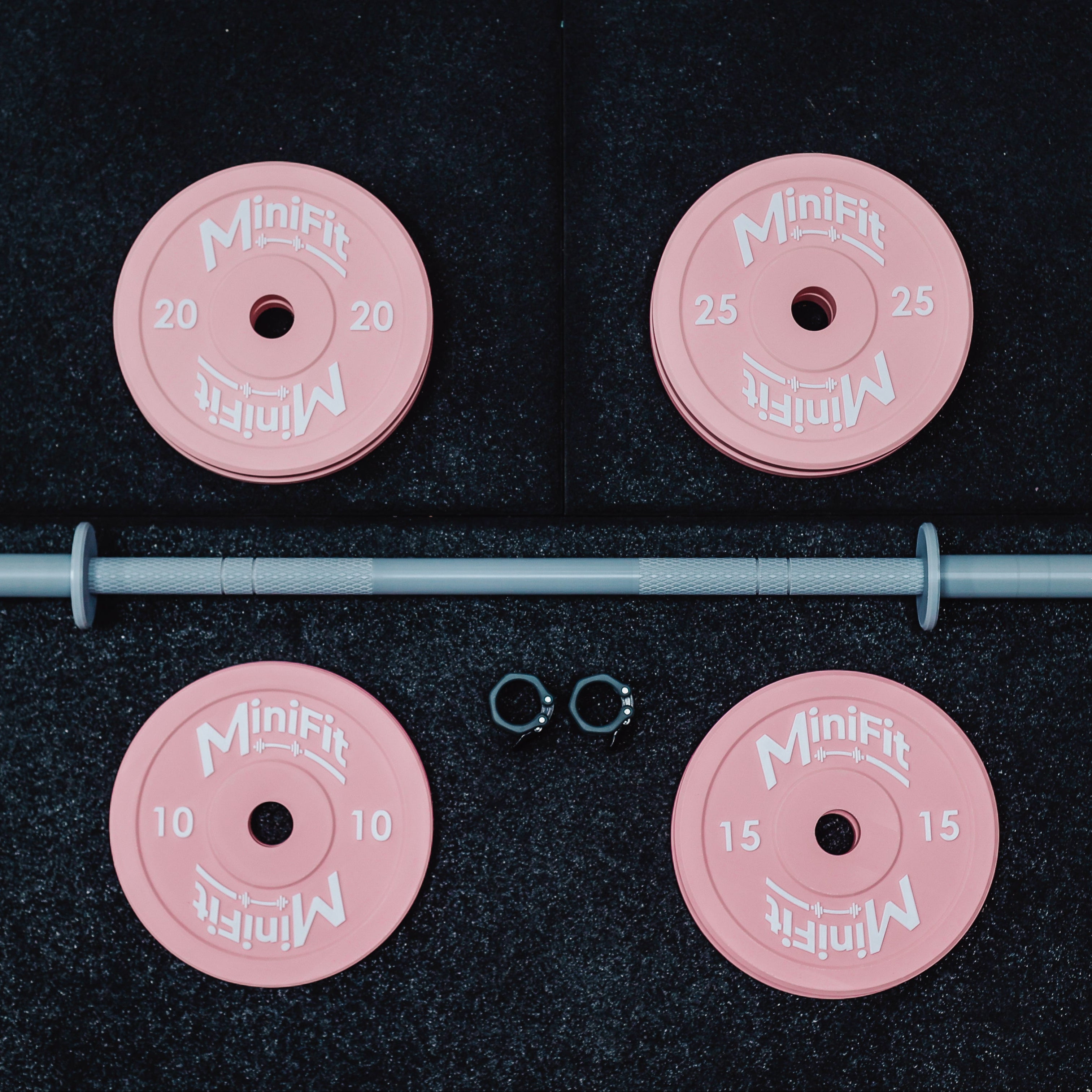 Pink weight plates with a bar on a black background