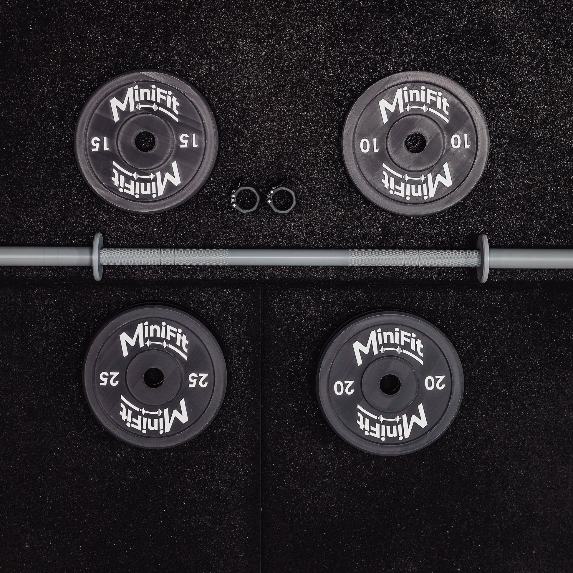 Set of child's weight plates and barbell on a black gym mats