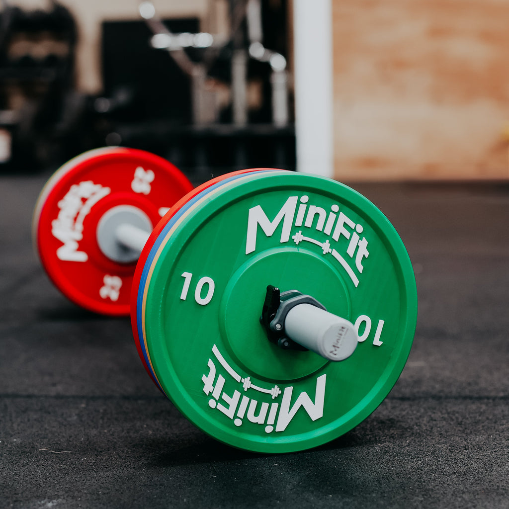 Children's bumper weight plates with Minifit branding on a gym floor.